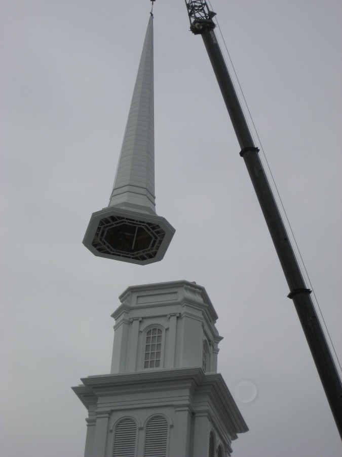 Steeple Spire being hoised and lowered into place
